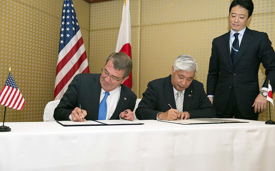 Secretary of Defense Ash Carter signs a reciprocal defense agreement with Japanese Minister of Defense Gen Nakatani in Singapore, June 4, 2016.