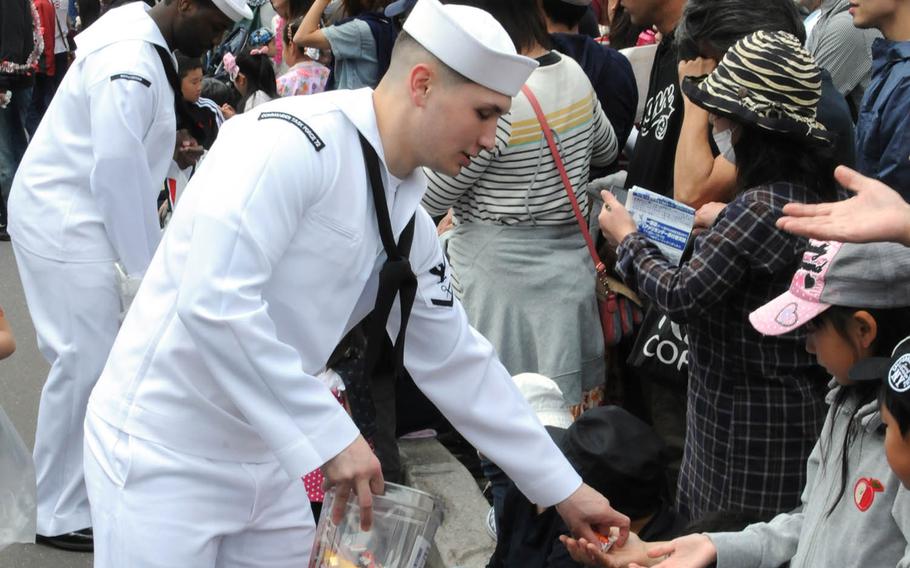 Sailors from Misawa Air Base, Japan, hand out candy during the 28th annual American Day Parade, Sunday, June 5, 2016. A ban on nonessential off-base trips ended Friday, June 10, 2016, but rules forbidding alcoholic drinks for sailors in Japan will last longer, a Navy statement said.