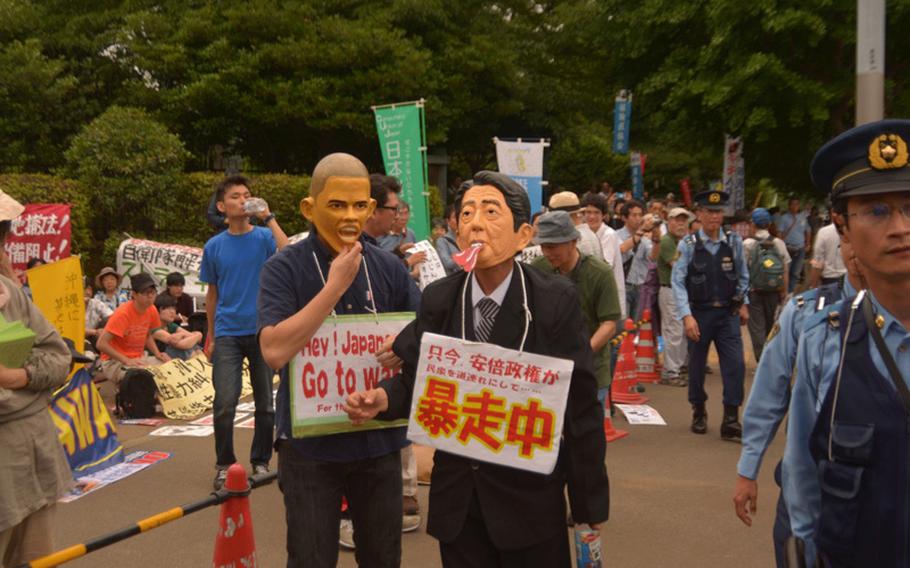 Two protesters dress up as President Barack Obama and Japanese Prime Minister Shinzo Abe during a protest outside the Diet building June 19, 2016. 
