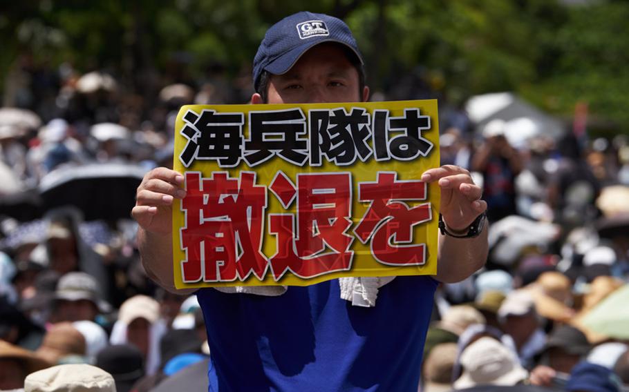 A protester holds up a sign translated into ''Withdraw Marines'' from Okinawa June 19, 2016 in Naha, Japan, the capital city of Okinawa Prefecture. 

