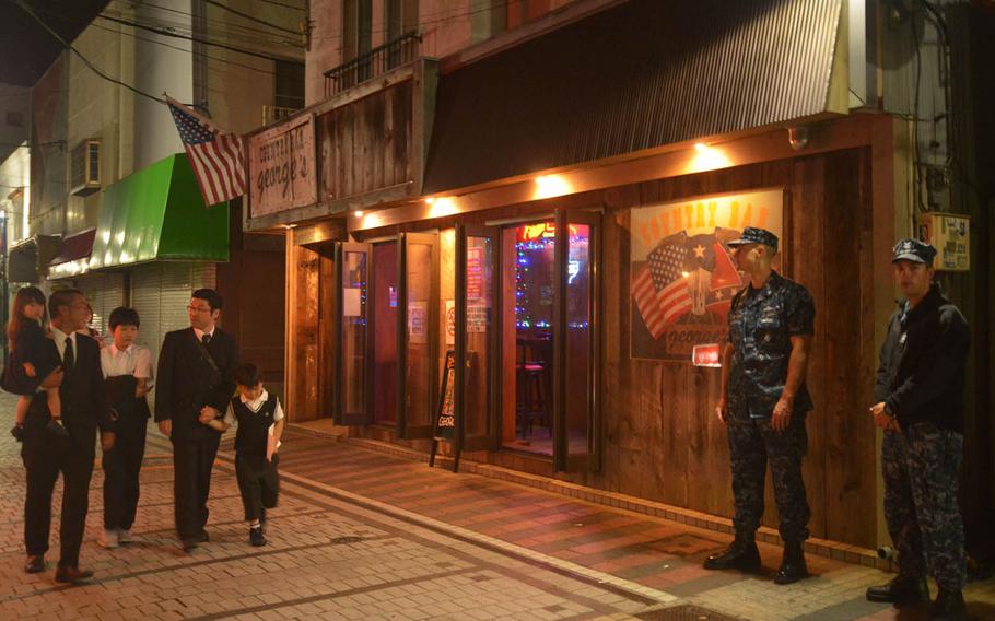 Michael Nelson, second from right, a Navy petty officer second class who works as an intelligence specialist with the 7th Fleet out of Yokosuka Naval Base, Japan, and Devon Hays, right, a petty officer second class assigned to the USS Blue Ridge, patrol Honch, a drinking district outside the base popular with servicemembers, Monday, June 6, 2016. A ban for sailors in Japan from nonessential off-base activities and drinking alcohol has been lifted, Navy officials announced Tuesday.