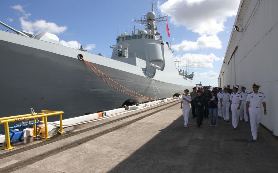 Chinese and American naval officers walk beside China's guided-missile destroyer Xian July 8, 2016, while it was docked at Joint Base Pearl Harbor-Hickam, Hawaii, for the Rim of the Pacific exercise.