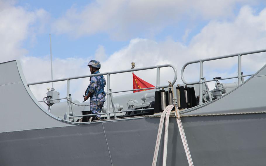 An armed sailor walks the bow China's guided-missile destroyer Xian while docked July 8, 2016, at Joint Base Pearl Harbor-Hickam, Hawaii, for the Rim of the Pacific exercise.