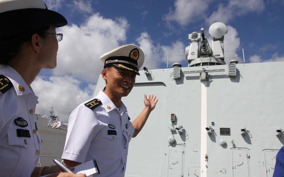 Cmdr. Sun Hong Bin, the executive officer of China's guided-missile destroyer Xian, explains some of the features of the ship's helicopter deck to visiting reporters July 8, 2016, while the ship was docked at Joint Base Pearl Harbor-Hickam, Hawaii, for the Rim of the Pacific exercise.