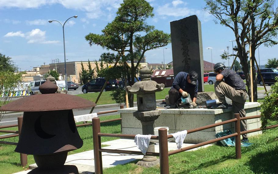 Japanese employees work on a memorial to John F. Kennedy at Yokota Air Base, Japan, Wednesday, Aug. 17, 2016. The monument, dedicated to the late president shortly after his assassination in November 1963, was moved from a traffic circle to a park that will open in September.