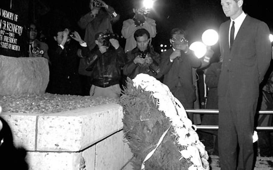 Then-Attorney General Robert Kennedy looks at a memorial for his brother, President John F. Kennedy, in January 1964 at Yokota Air Base, Japan. The memorial, contributed by Japanese base workers shortly after the president's November 1963 assassination, is now part of a monument park opening soon near the base library.