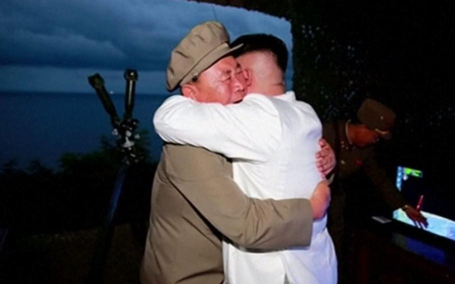 North Korean leader Kim Jong Un, right, hugs a soldier after a submarine-launched missile test Wednesday, Aug. 24, 2016.
