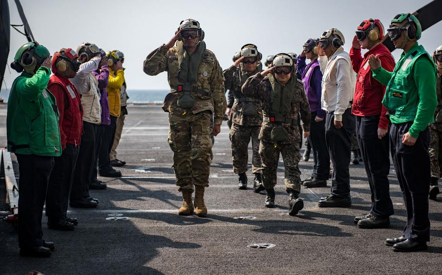 Sideboys from the aircraft carrier USS Carl Vinson salute Gen. Vincent Brooks, center left, U.S. Forces Korea commander, Gen. Lee Sun Jin, center right, chairman of the South Korean Joint Chiefs of Staff, center right, and Gen. Leem Ho-young, deputy commander of the Combined Force, on the flight deck, Sunday, March 12, 2017. 