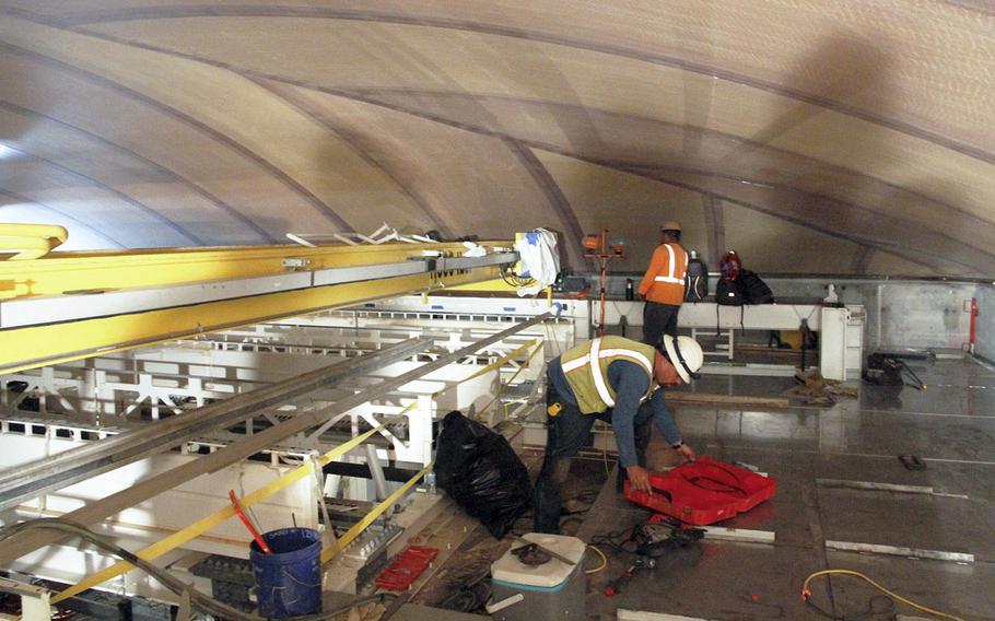 Workers stand below the electronically transparent Kevlar roof that covers one of the Space Fence radar chambers at Kwajalein Island.