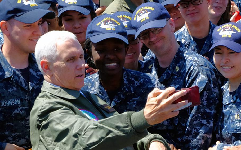 Vice President Mike Pence poses for a selfie with servicemembers aboard the USS Ronald Reagan in Yokosuka, Japan, Wednesday, April 19, 2017.