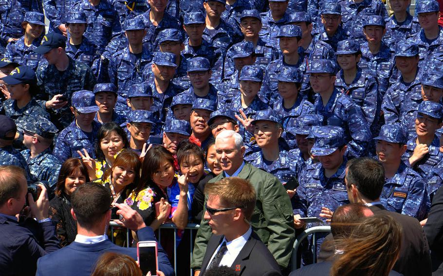 Vice President Mike Pence poses with members of the Japan Maritime Self-Defense Force after giving a speech aboard the USS Ronald Reagan in Yokosuka, Japan, Wednesday, April 19, 2017.