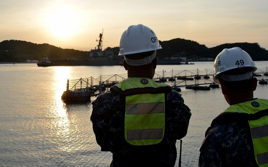 Sailors watch pier-side as the destroyer USS Fitzgerald returns to Fleet Activities Yokosuka on June 17, 2017 after a collision with a merchant vessel while operating southwest of Yokosuka, Japan.