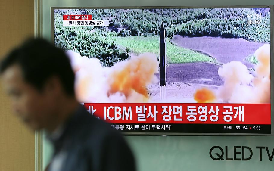A man at Seoul Train Station in Seoul, South Korea, walks by a TV screen showing a local news program reporting about North Korea's missile firing, Wednesday, July 5, 2017.