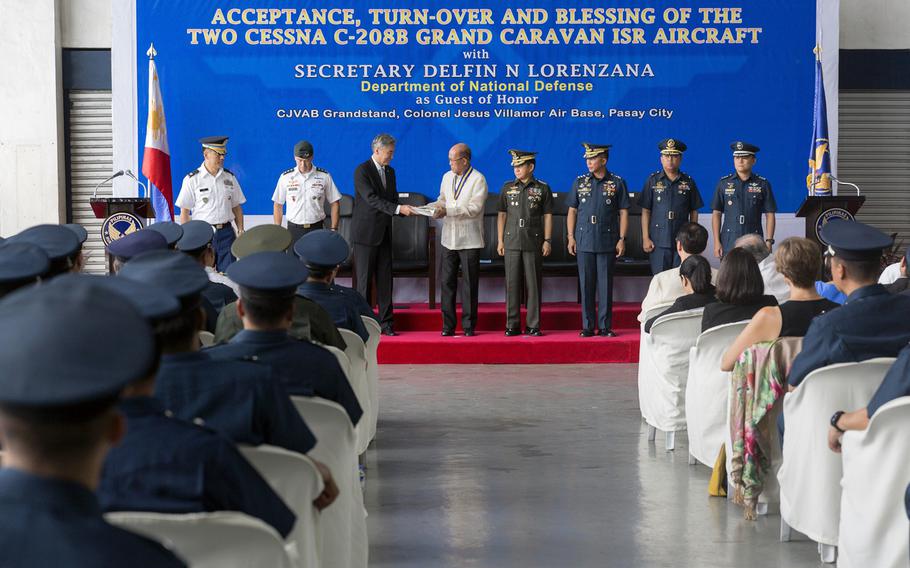 U.S. and Philippine officials gather at Villamor Air Base in Pasay City, Philippines, for a ceremony to transfer two new Cessna 208B surveillance planes to the Philippine Air Force, July 27, 2017.