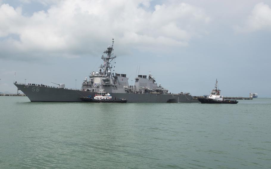 Tugboats from Singapore assist the Guided-missile destroyer USS John S. McCain (DDG 56) at it steers towards Changi Naval Base, Republic of Singapore following a collision with the merchant vessel Alnic MC while underway east of the Straits of Malacca and Singapore on Aug. 21.