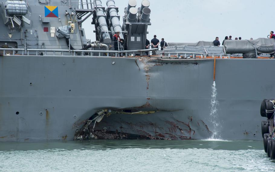 Damage to the portside is visible as the guided-missile destroyer USS John S. McCain moves toward Changi Naval Base, Republic of Singapore, after a collision with the merchant vessel Alnic MC while underway east of the Straits of Malacca and Singapore on Aug. 21, 2017. 