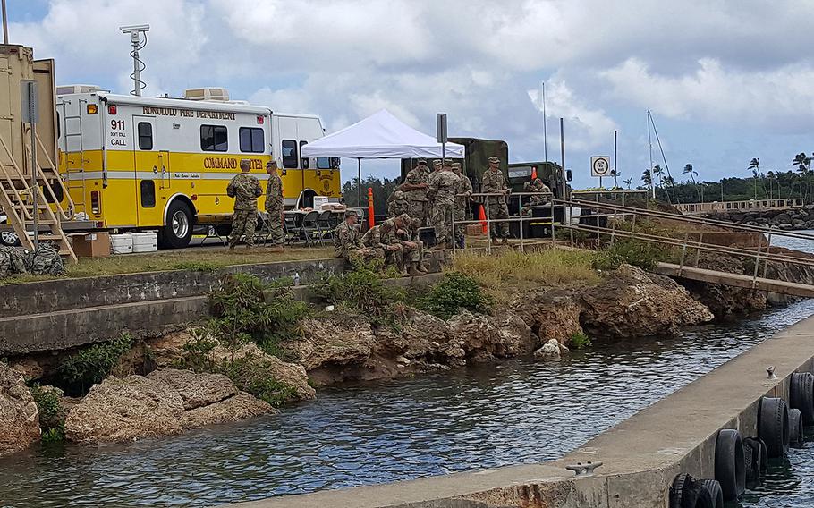 Military personnel gather at the search and rescue command center on Wednesday, Aug. 16, 2017 in Haleiwa, Hawaii. Rescue crews were searching for five soldiers who were aboard an Black Hawk helicopter that crashed several miles off Oahu's North Shore late Tuesday. 
