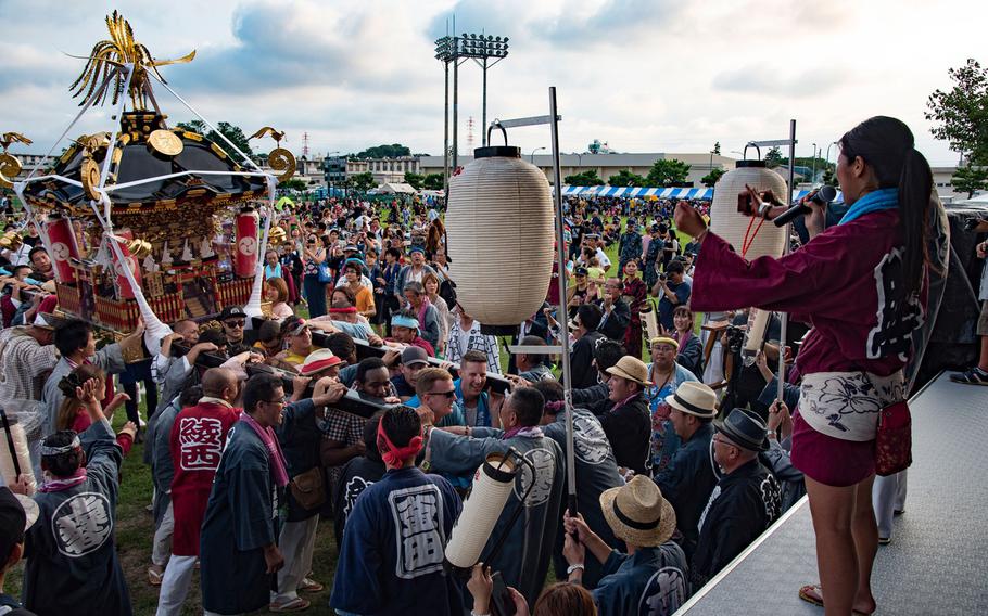 Sailors assigned to Naval Air Facility (NAF) Atsugi join members of the local community carrying a mikoshi, a portable shrine, during the installation's Bon Odori open base event.