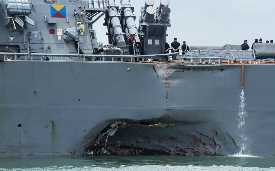 The USS John S. McCain shows damage to the portside of the hull while docked on Monday, Aug. 21, 2017 at Changi Naval Base in Singapore.