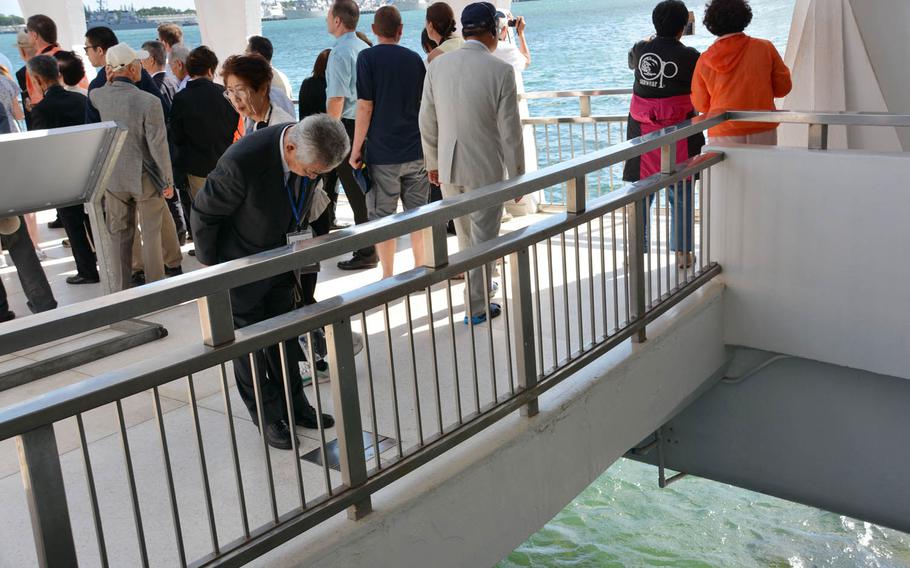 Yukio Udagawa, vice president of the Japan War-Bereaved Families Association, bows in prayer on Thursday, Sept. 21, 2017, over a portal at the USS Arizona Memorial for viewing "black tears," oil seeping from the ship that has been submerged since being sunk 75 years ago during the surprise attack on Pearl Harbor.