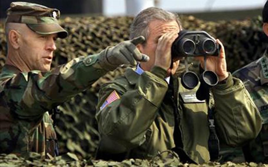 President George W. Bush looks through binoculars at North Korea during a visit to the Demilitarized Zone on Feb. 20, 2002. 