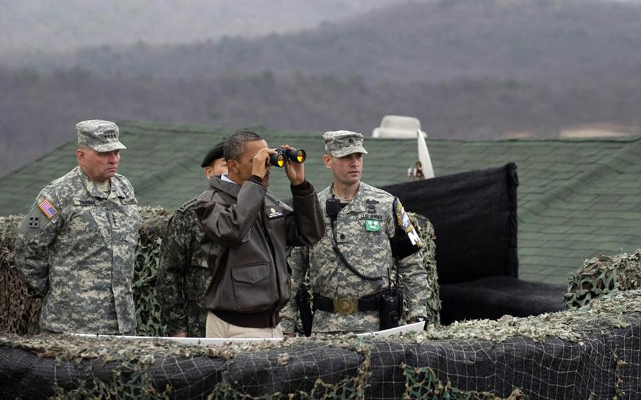 President Barack Obama looks through binoculars at North Korea during a visit to the Demilitarized Zone on March 25, 2012.