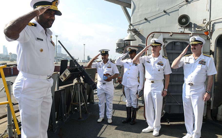 U.S. Navy Rear Admiral Gregory Harris, commander of Carrier Strike Group 11, right, and Capt. Justin A. Kubu, commanding officer of the USS Princeton, middle, salute Commodore Sanjeewa Dias, the director of naval operations Sri Lankan Navy, as he comes aboard the Princeton during a port visit on Saturday, Oct. 28, 2017.