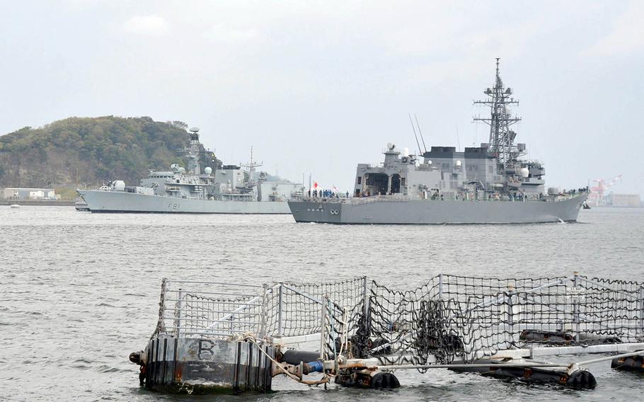 The British Royal Navy frigate HMS Sutherland, left, passes the Japanese destroyer JS Ikazuchi as it arrives at Yokosuka Naval Base, Japan, Wednesday, April 11, 2018.