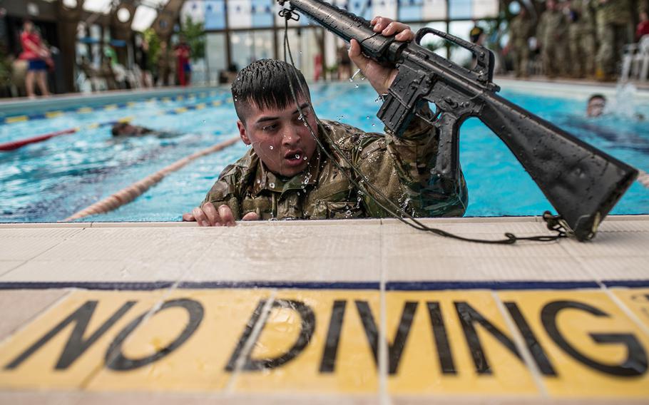 Spc. Cristepher Colon grabs a rifle during the 2nd Infantry Division's Best Warrior competition at Camp Hovey, South Korea, Wednesday, April 11, 2018.