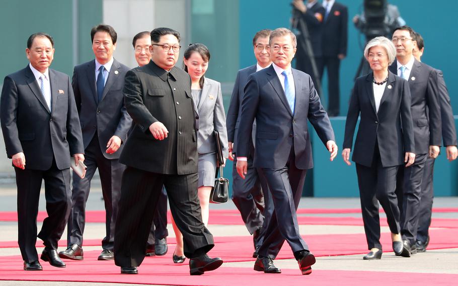 North Korean leader Kim Jong Un and South Korean President Moon Jae-in are flaked by aides and other political leaders including Kim's sister Kim Yo Jong, center, on Friday, April 27, 2018.