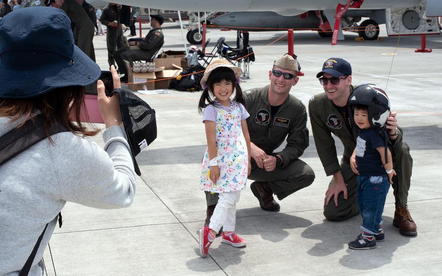 Navy pilots from Carrier Air Wing 5 pose with children in front of an EA-18G Growler at Marine Corps Air Station Iwakuni, Japan, Saturday, May 5, 2018.