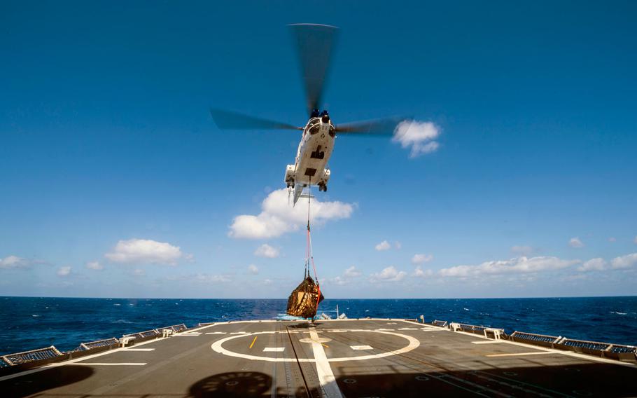 An SA-330J Puma helicopter, assigned to the Lewis and Clark-class dry cargo ship USNS Wally Schirra (T-AKE 8), takes off with cargo from the flight deck of the Ticonderoga-class guided-missile cruiser USS Antietam (CG 54) during a vertical replenishment in the Philippine Sea in March 2018.