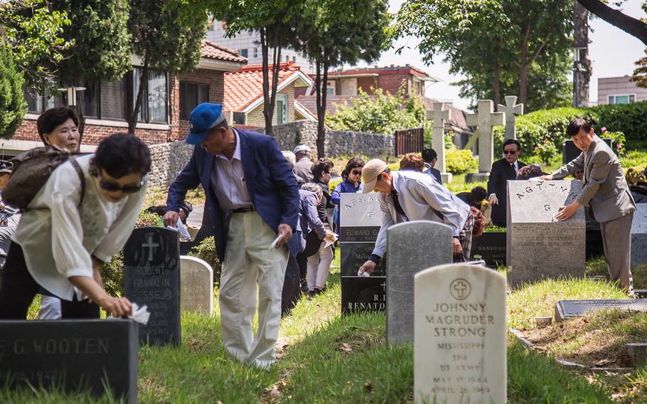 South Koreans clean U.S. grave sites at Yanghwajin Cemetery in Seoul, South Korea, Monday, May 28, 2018. 