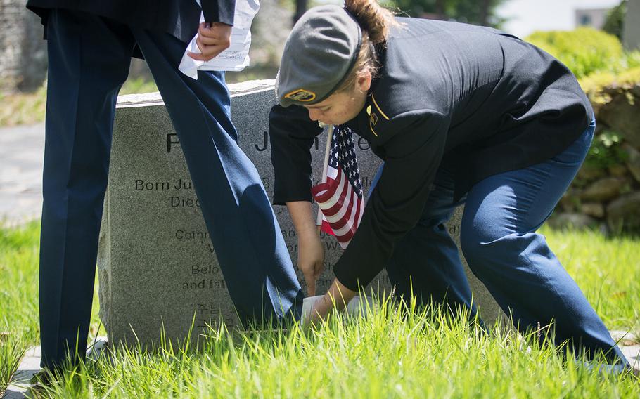 A JROTC cadet plants a U.S. flag at Yanghwajin Cemetery in Seoul, South Korea, Monday, May 28, 2018. 