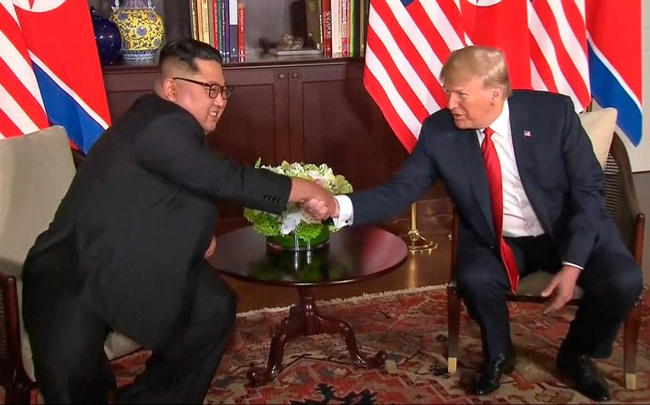 In this image made from video provided by Host Broadcaster Mediacorp Pte Ltd,, U.S. President Donald Trump and North Korean leader Kim Jong Un shake hands ahead of their meeting at Capella Hotel in Singapore, Tuesday, June 12, 2018.