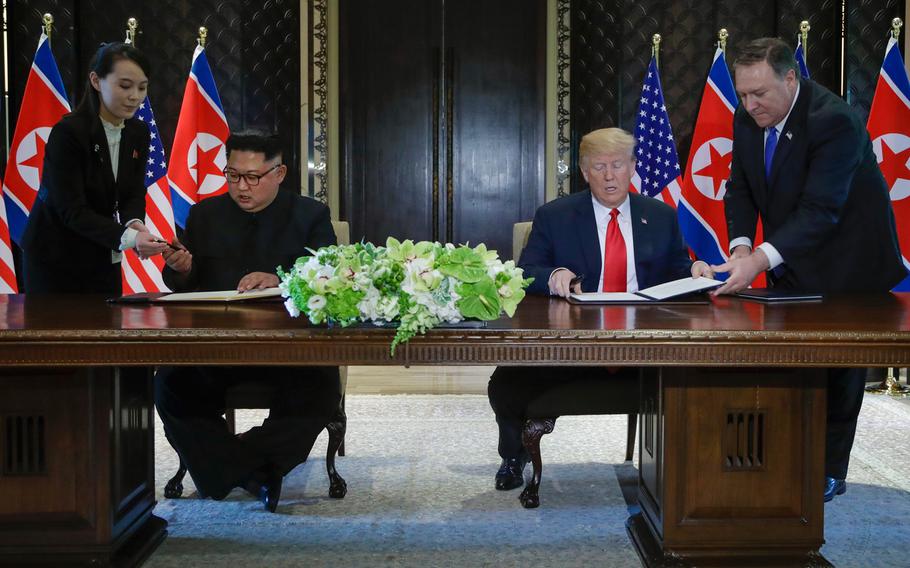 North Korea leader Kim Jong Un and U.S. President Donald Trump prepare to sign a document at the Capella resort on Sentosa Island Tuesday, June 12, 2018 in Singapore.