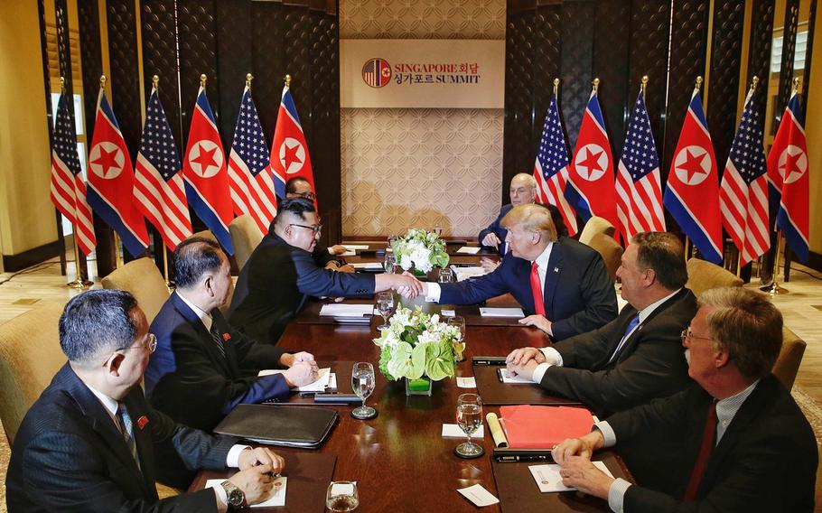 North Korea's Kim Jong Un, third from left, shakes hands with U.S. President Donald Trump, third from right, in Singapore on June 12, 2018.