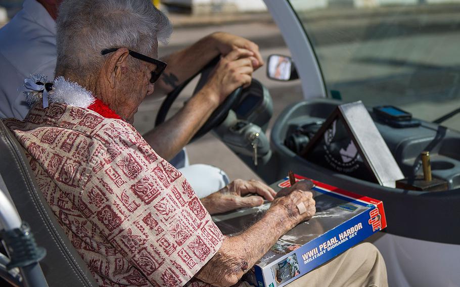 Retired Chief Boatswain's Mate and Pearl Harbor survivor Ray Emory autographs a World War II G.I. Joe toy for the USS O'Kane Command Master Chief Jay’e Jerrod’e Bell during a farewell ceremony at Pearl Harbor on June 19, 2018. Emory was responsible for the identification of unknown service members killed in the attacks on Pearl Harbor who were buried in unnamed graves.