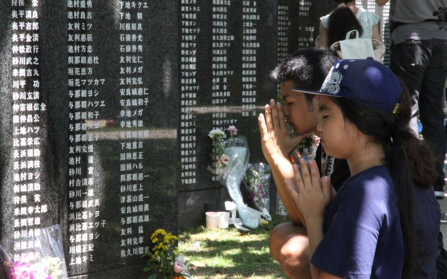 A family prays for lost loved ones at the Okinawa Peace Memorial Park’s Cornerstone of Peace memorial prior to the annual Irei no Hi ceremony, commemorating the 73rd anniversary of the Battle of Okinawa on Saturday, June 23, 2018.