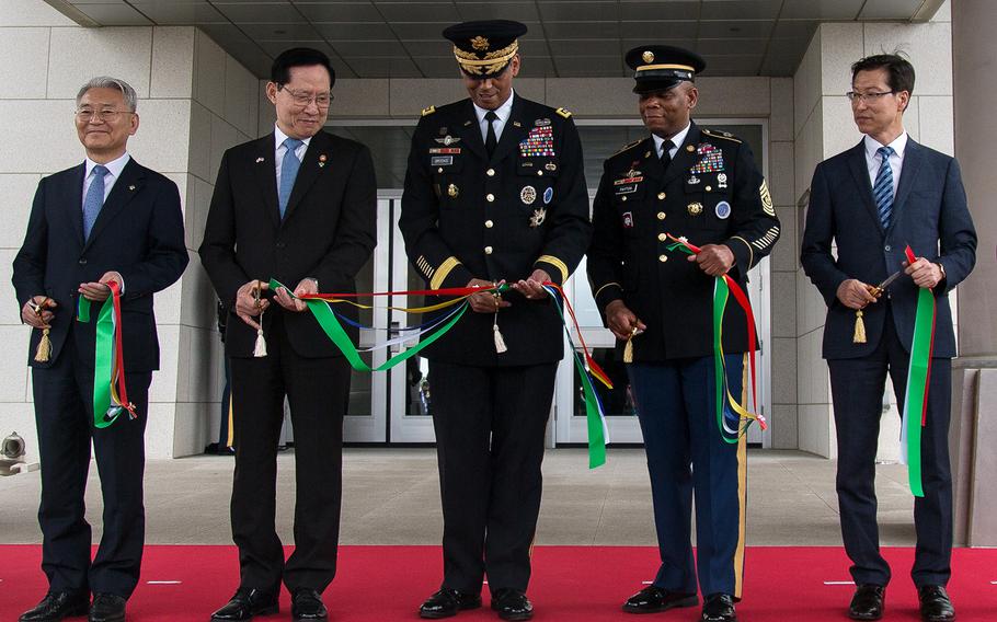 Gen. Vincent Brooks, United States Forces Korea commander cuts the last piece of ribbon with help from the South Korean Defense Minister Song Young-moo as the new USFK headquarters is officially opened at Camp Humphreys, South Korea, Friday, June 29, 2018.   