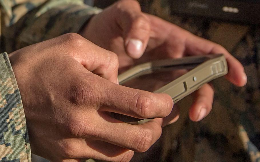 Marines with Kilo Company, 3rd Battalion, 4th Regiment, 1st Marine Division, look at an Android phone with enhanced Beartooth radio capabilities, which allow them to talk, text, and see teammates on a map without requiring cellular service or Wi-Fi, during Urban Advanced Naval Technologies Exercise 2018 (ANTX18), March 21, 2018.