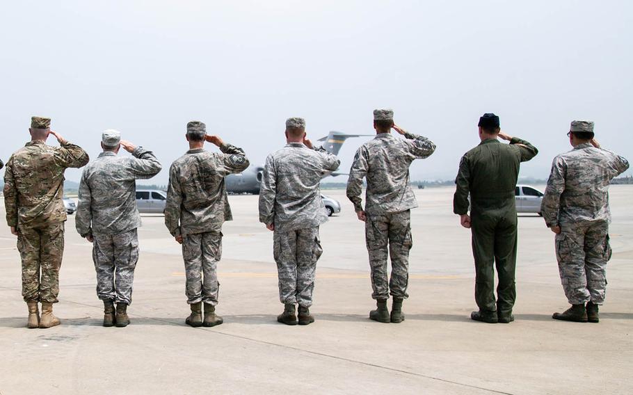 Servicemembers at Osan Air Base, South Korea, salute an aircraft carrying remains repatriated from the North, Friday, July 27, 2018.