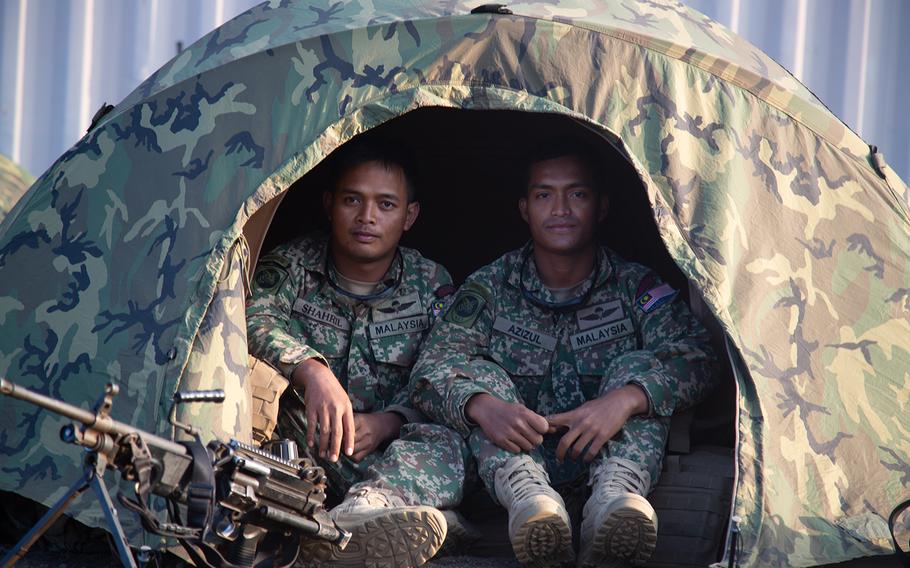 A pair of Malaysian Marines pose in their tent at Pohakuloa Training Area, Hawaii during the Rim of the Pacific exercise, July 15, 2018. 