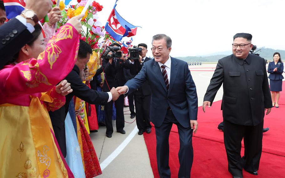 South Korean president Moon Jae-in (left) and North Korean leader Kim Jong Un greet North Korean citizens on Sept. 18, 2018. 