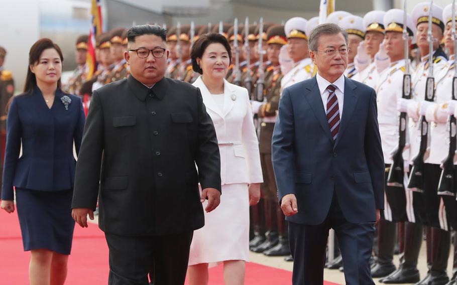 South Korean president Moon Jae-in (right) and his wife, Kim Jung-sook, walk with North Korean leader Kim Jong Un and his wife, Ri Sol-ju, on a tarmac in North Korea on Sept. 18, 2018.