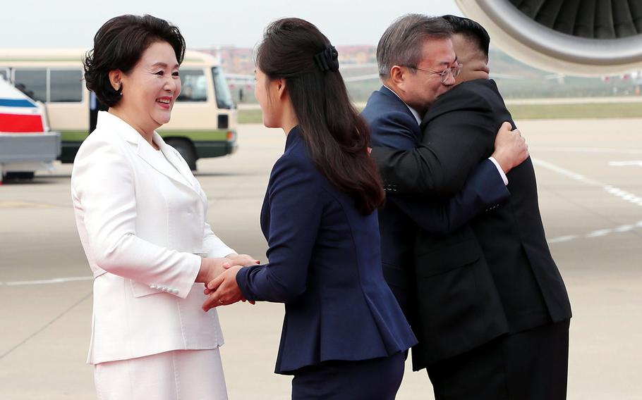 South Korean president Moon Jae-in (left) and his wife, Kim Jung-sook, greet North Korean leader Kim Jong Un and his wife, Ri Sol-ju, on a tarmac in North Korea on Sept. 18, 2018.