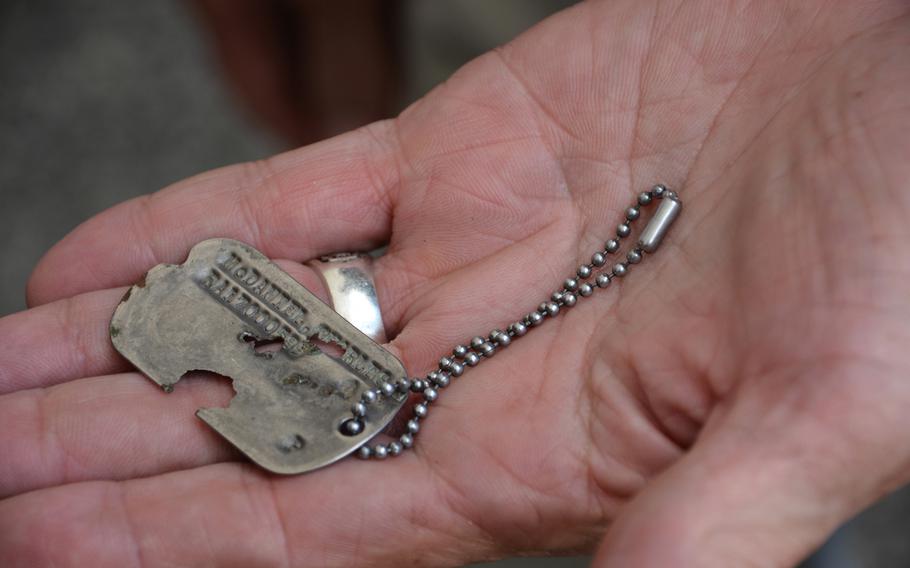 Charles McDaniel Jr., holds the dog tag worn by his namesake father during the Korean War. His father’s remains and dog tag were returned by North Korea in July.
