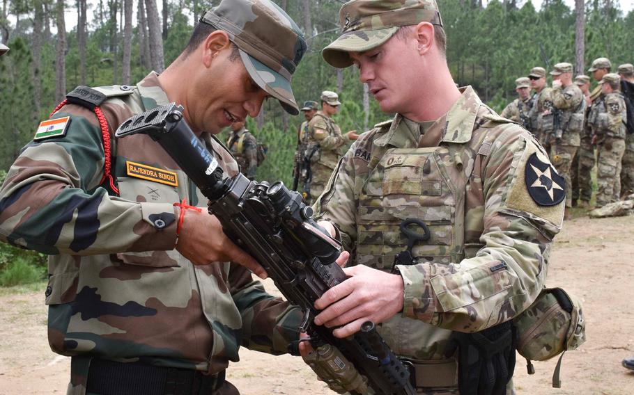 A soldier with U.S. Army's 1st Battalion, 23rd Infantry Regiment, talks about an M249 Squad Automatic Weapon with a soldier from the Indian army's 99th Mountain Brigade Sept. 24, 2018, at Chaubattia Military Station, India, during the Yudh Abhyas exercise.