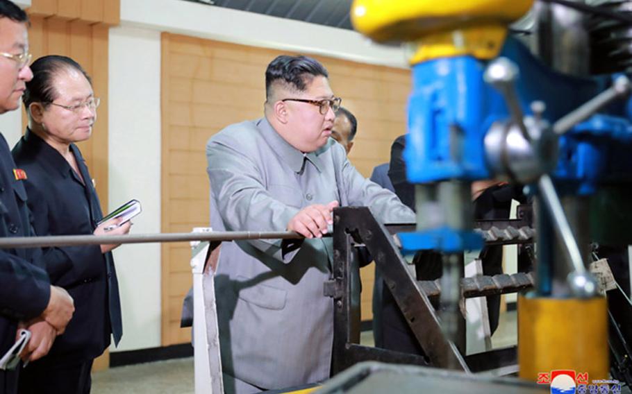 North Korean leader Kim Jong Un inspects machinery factories and other economic facilities near the border with China on an unspecified date. 