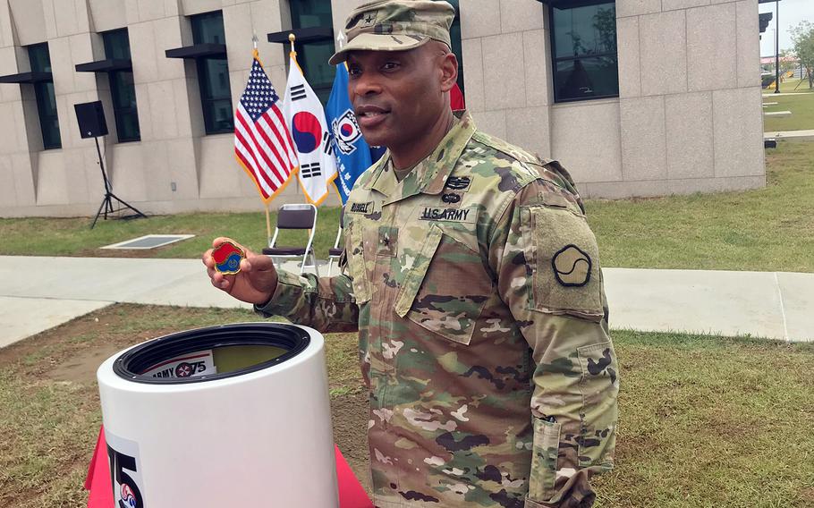 Brig. Gen. Michel Russell Sr., who leads the Daegu-based 19th Expeditionary Sustainment Command, displays a coin commemorating his unit's 55th anniversary, which he later placed inside a time capsule that was sealed on Camp Humphreys, South Korea, Monday, June 10, 2019, to celebrate the Eighth Army's 75th anniversary. 